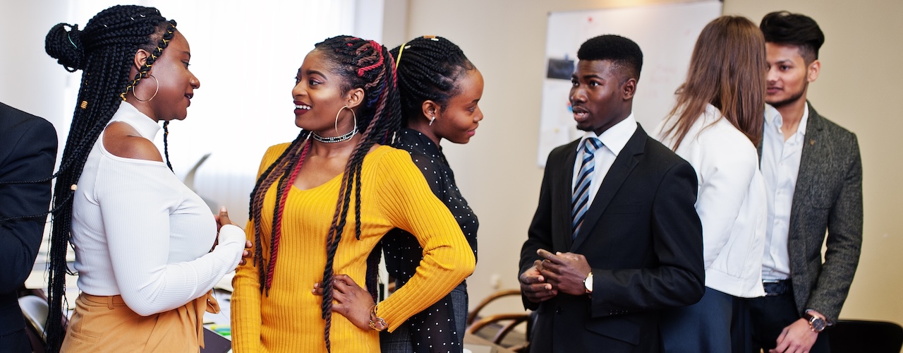 Multiracial business people standing at office and discuss together. Diverse group of employees in formal wear.